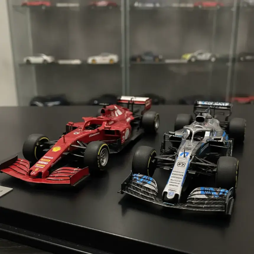 Coleção de miniatura de carros de Formula 1, exibindo modelos clássicos e modernos lado a lado.